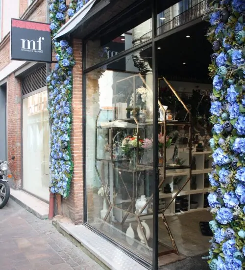 La devanture de la boutique Monsieur Flower, au 8 rue baronie à Toulouse, ornée de fleurs bleues.